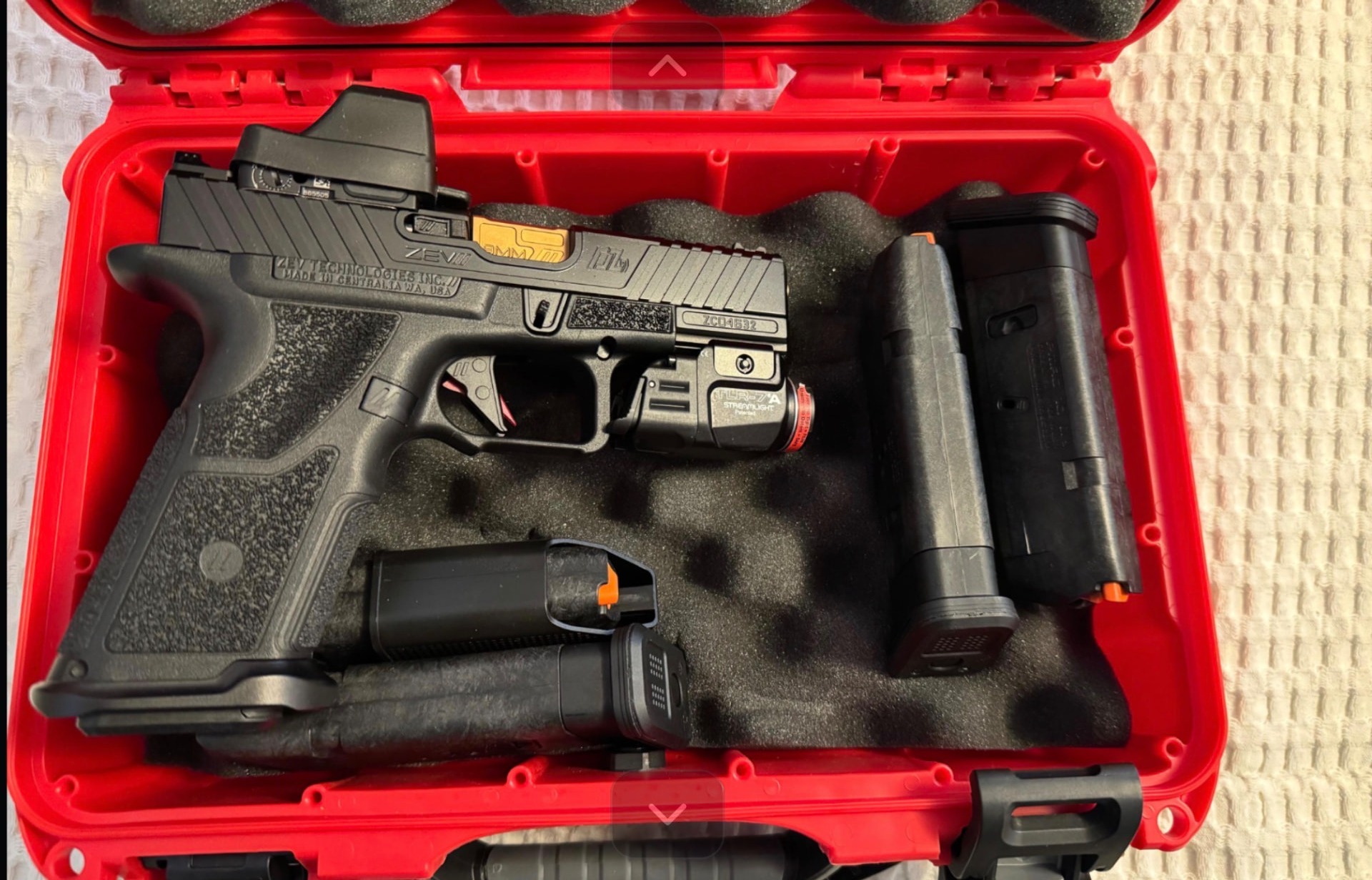 ZEV OZ9 in its case with magazines and a weapon light